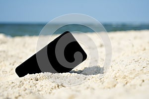 Mobile touch phone in sand on beach