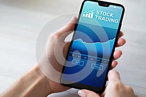 Mobile trading application with stock market chart on smartphone screen. Forex, investment business technology concept