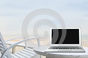 Mobile work office on the beach with blank laptop screen