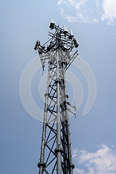 Mobility cell site against a cloudy sky, self-supporting tower with panel antennas