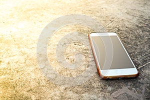 Moblie smart phone on stone table sun light background.