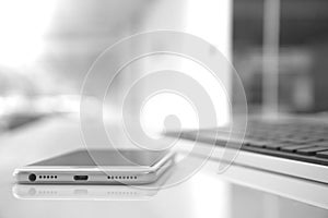 Moblile phone and computer keyboard on working desk background