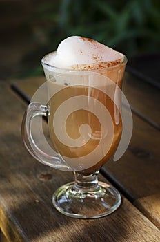 Mochaccino cup whit cream on top of a wooden table