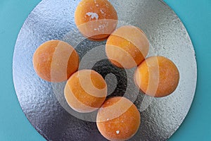 Mochi with mango. Premium ice-cream wrapped in sweet rice dough, traditional japonese desert. Gluten Free. Orange on pastel blue