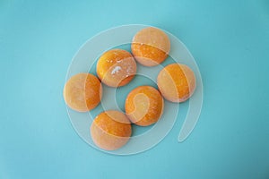 Mochi with mango. Premium ice-cream wrapped in sweet rice dough, traditional japonese desert. Gluten Free. Orange on pastel blue