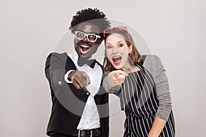 Mock, sneer concept. Colorful couple pointing fingers at camera photo