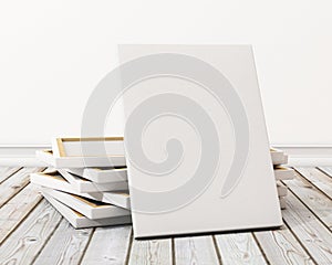 Mock up blank canvas or poster with pile of canvas on floor and wall, background