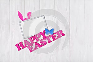 Mock up of blank white frame with pink text of happy easter and bunny ears