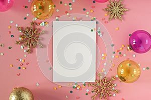 Mock up card on a pink background with their Christmas decorations and confetti. Invitation, card, paper. Place for text