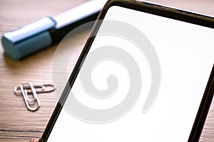 Mock up of cell phone in hand with white blank screen. smartphone mockup with empty display with a wooden table on the background