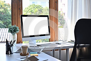 Computer with empty display on white table in modern office.
