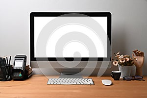 Mock up computer with empty screen on wooden desk.