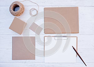 Mock up of Craft set of empty different items, boxes for gift, envelops, card, sheet, rope on wooden background