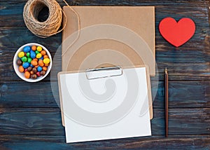 Mock up of empty craft envelops and  sheet for calligraphy, rope, sweet, ink pen, red heart on wooden background