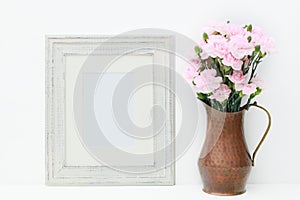 A mock up of a empty white frame and flowers.