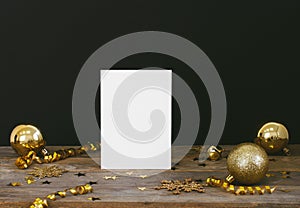 Mock up greeteng card on wood rustic dark background with Christmas decorations glitter snowflakes, baubles, bell, serpentine and