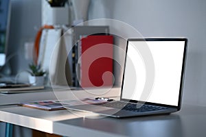 Mock up laptop computer with white screen on graphic designer or designer workspace.