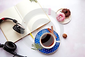 Mock up notepad with headphones, coffee cup and cinnamon sticks with doughnuts. Taking webinar, listen to music or