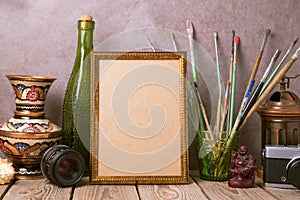 Mock up poster frame with vintage artistic objects and old camera on wooden table