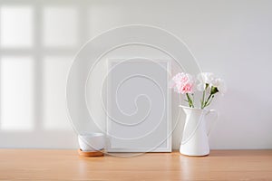 Mock up protrait photo frame with flowers on table