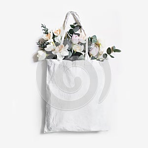 Mock-up scene of blank shopping canvas tote bag with pink tulips, daffodils flowers and eucalyptus isolated on white