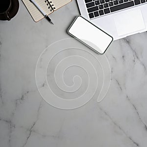 Mock up smart phone with blank screen, laptop, notebook and copy space on marble background.