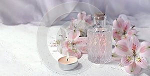 Mock up spa aromatherapy concept with perfume glass or aroma oil glass, flowers and candle on light background.