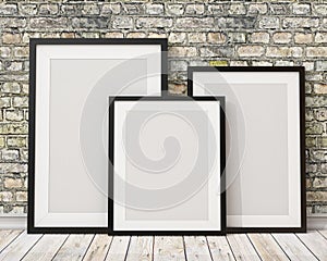 Mock up three blank black picture frames on the old brick wall and the wooden floor, background photo