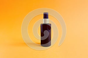 Mock-up of unbranded brown plastic spray bottle on a textured bright orange background. Cosmetic bottle container for branding