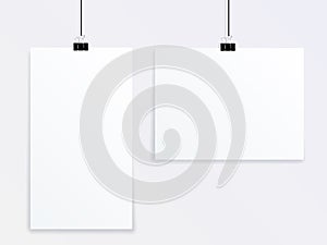 Mock up vector of two posters of different sizes hanging on a gray wall on office clothespins.