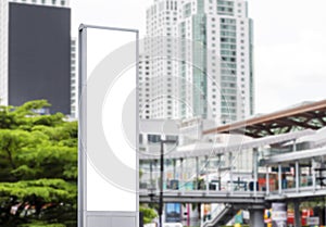 Mock up white LED display vertical billboard on tower pole with cityscape view. clipping path for mockup