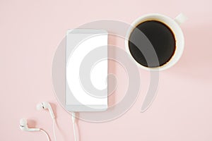 Mock up of white smartphone included clipping path on touchscreen, with earbud  and a cup of hot coffee on pastel pink background