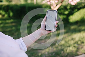 Mock up woman hold smartphone in left hand