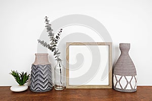 Mock up wood frame with clay vases, succulent plant and eucalyptus branch on a shelf