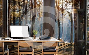 Mock up of wooden desk, laptop with white blank scrreen ,smartphone and boooks in modern house with pine forest background