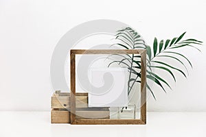 Mock up wooden frame with green tropical leaves.