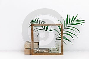 Mock up wooden frame with green tropical leaves. Nordic decorations,