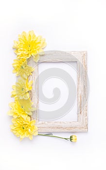 mock up in a wooden frame on a white background, next to yellow flowers. Summer composition.