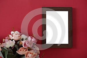 Mock-up wooden photo frame with space for text or picture on red background and flower