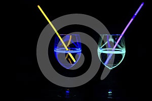 Mocktail wine glass filled with decorated refreshing alcohol liquid and colorful straw with black background for nightlife party