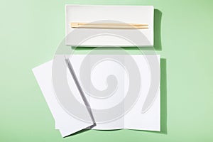 Mockup asian cuisine restaurant menu or brochure, sushi plate and food sticks on green background