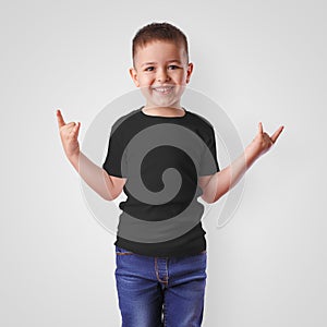 Mockup of black childrens t-shirt on a boy in blue jeans, cute child in blank clothes for presentation of design,pattern