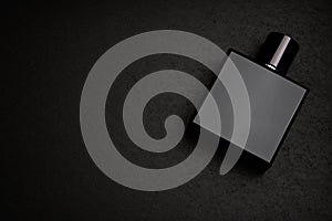 Mockup of black fragrance perfume bottle mockup on dark empty background. Top view. Horizontal.