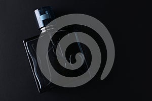 Mockup of black fragrance perfume bottle mockup on dark empty background. Top view. Horizontal