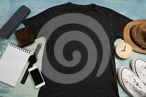Mockup of a black t-shirt blank shirt template with accessories on the wooden blue table background, lifestyle and travel concept