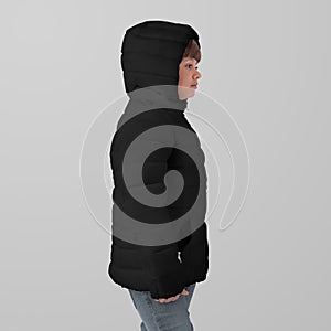 Mockup of a black winter kids puffer jacket on a girl in hoodie, side view,  on background