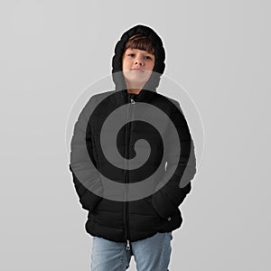 Mockup of black winter kids puffer jacket on hooded girl, front view,  on background in studio