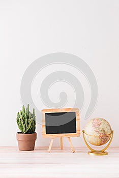 Mockup blackboard frame, globe, cactus on well arranged desk