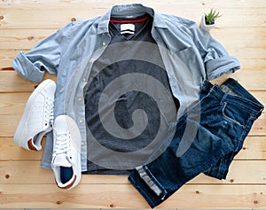 Mockup of blank gray t shirt and jean, white sneakers and denim pants on  wooden background. Shirt design for man close up. Flat
