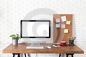 Mockup blank screen computer on wooden desk. desktop empty white screen, with workspace and office supplies on table